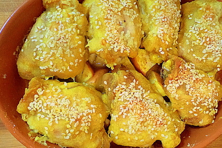 Фото к рецепту: Бедрышки цыпленка запеченные на яблочной перинке с острой приправой и кунжутом.