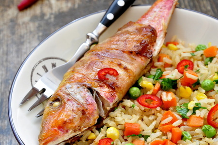 Фото к рецепту: Барабулька в беконе с жареным рисом и овощами