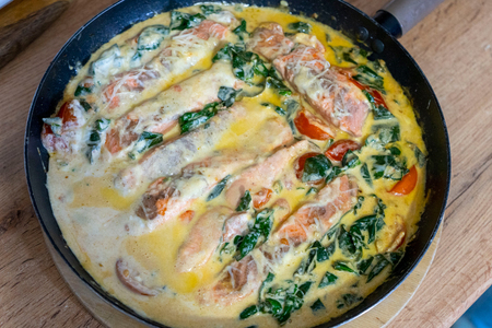 Фото к рецепту: Красная рыба в сливочном соусе с томатами и шпинатом