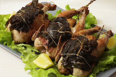 Фото к рецепту: Цыплята-корнишоны с беконом в виноградных листьях