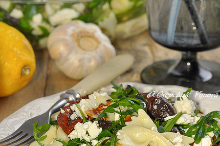 Фото к рецепту: Салат-фарфалле с рукколой, козьим сыром и вялеными томатами с чесночным соусом.