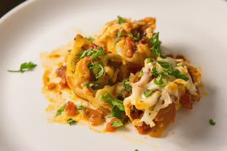 Фаршированные макароны ракушки конкильони с начинкой из сыра и курицы под томатным соусом в духовке.