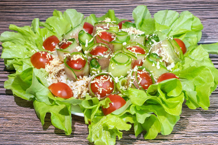 Салат с тунцом и свежими овощами в листьях салата