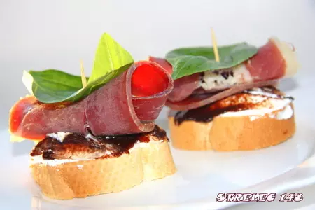 Кростини с хамоном, козьим сыром и пастой из фиников.